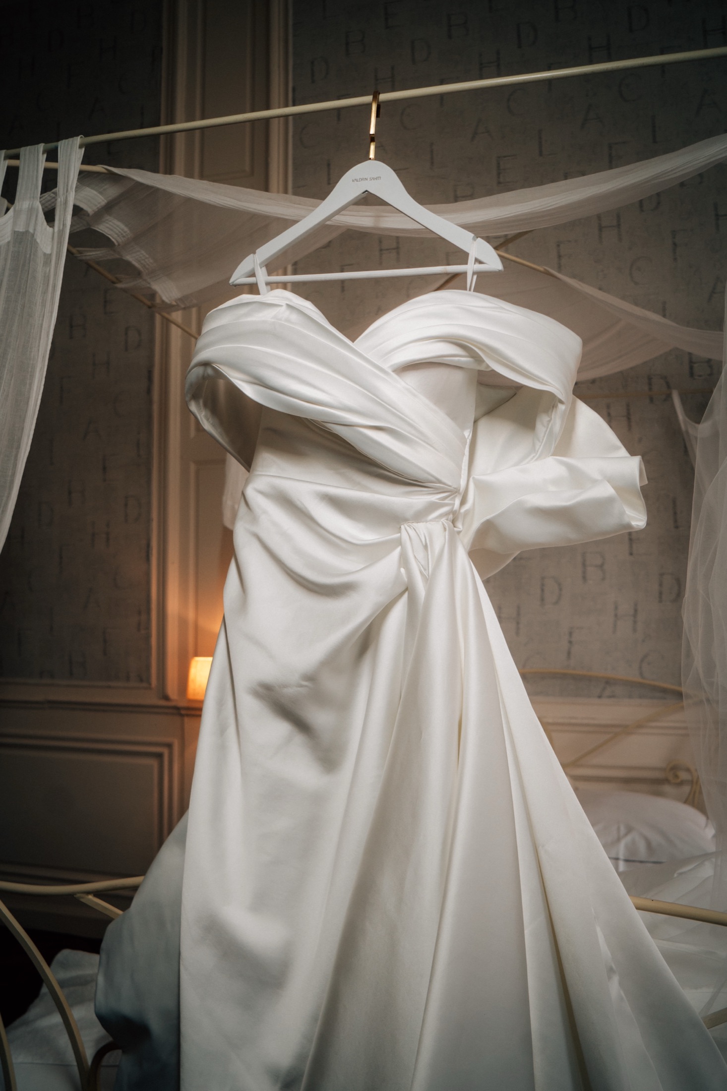 Weißes Brautkleid, hängend im abgedunkelten Raum