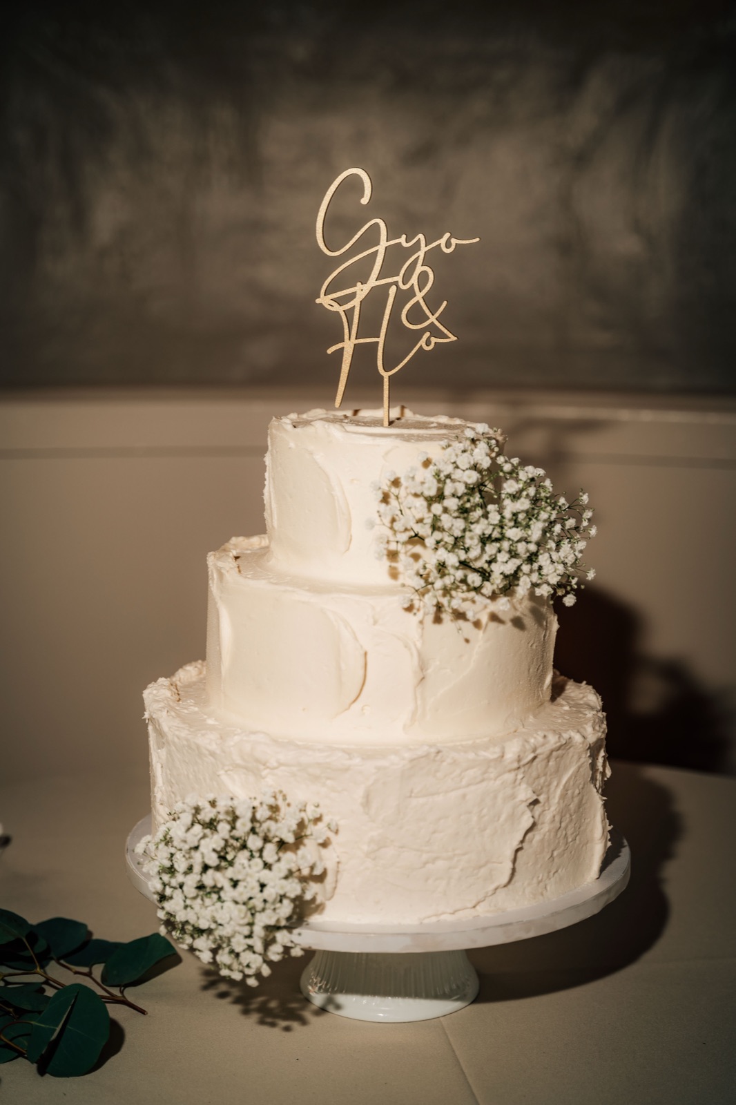 Dreistöckige Hochzeitstorte mit goldenem Monogramm-Topper